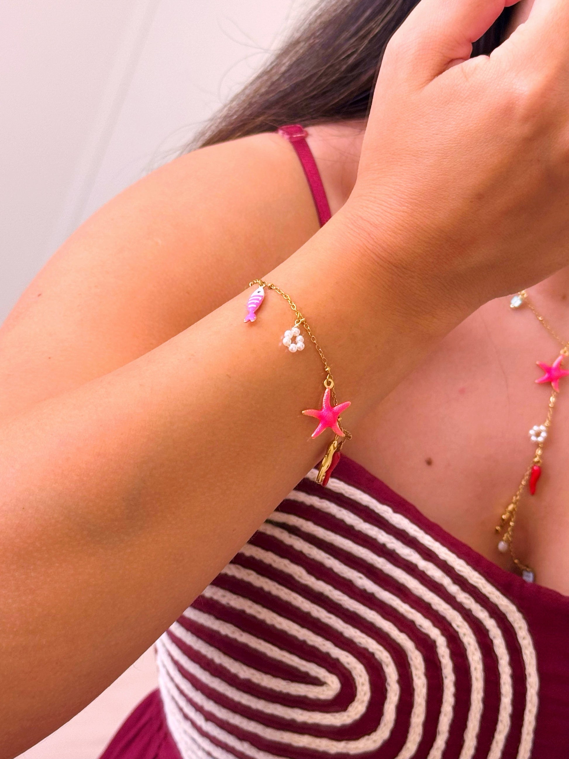Pulseira com estrela do mar rosinha e vários pendentes | Dourado