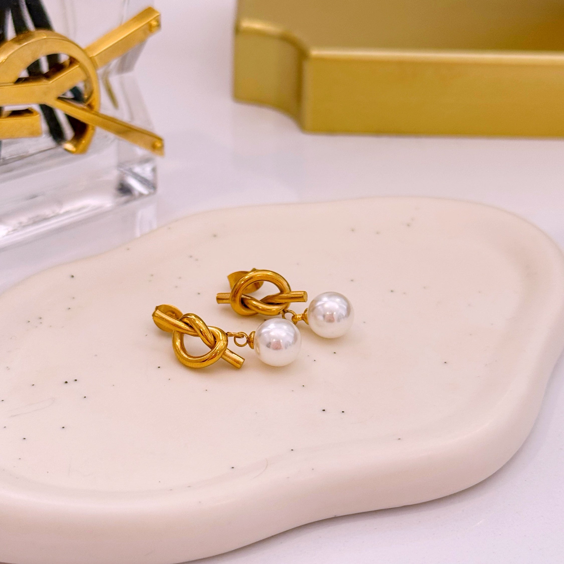 Brincos efeito nó com pérola em pendente | Dourado