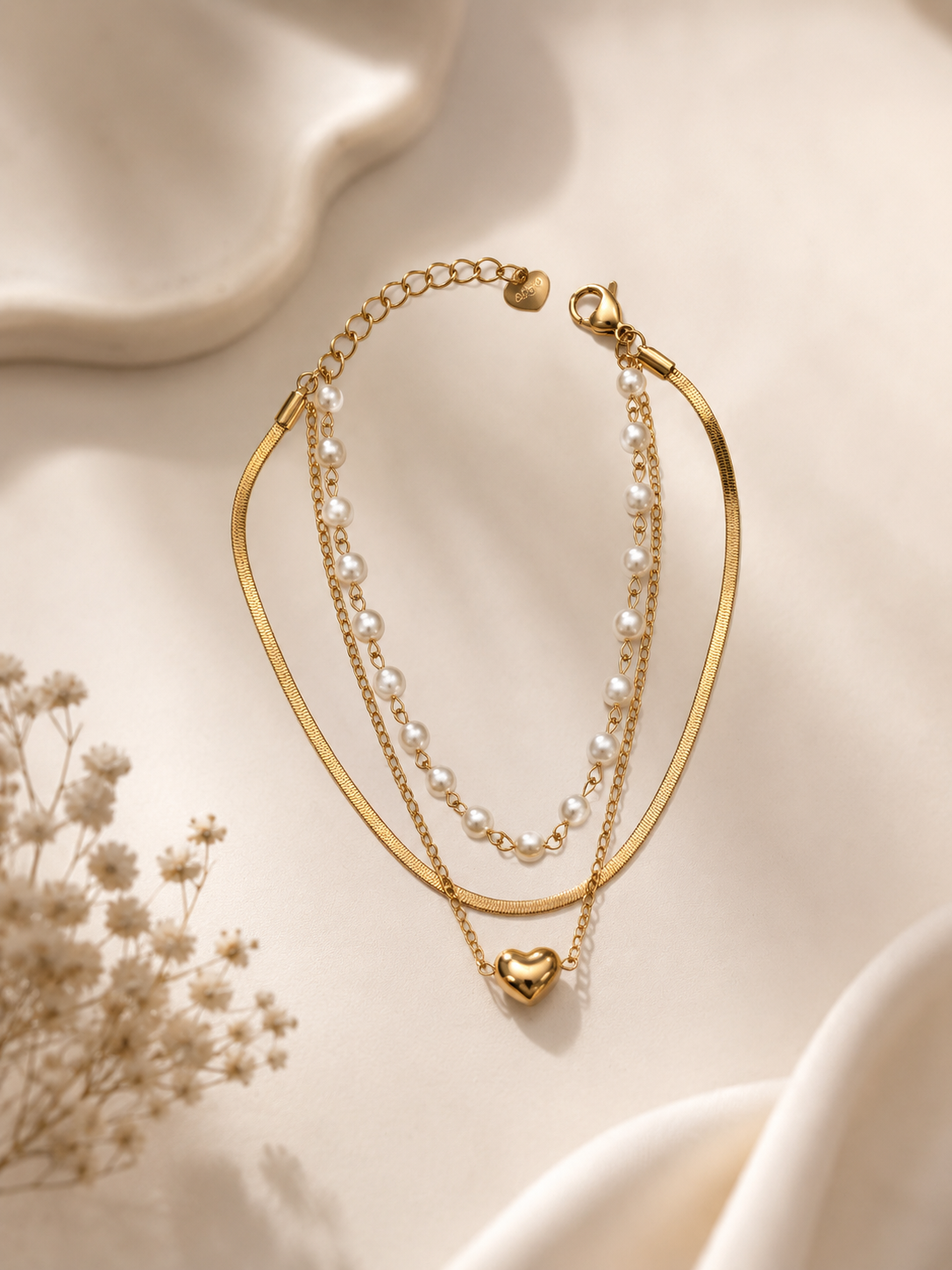 Pulseira efeito triplo • malha achatada, fininha com pérolas e fininha com coração | Dourado
