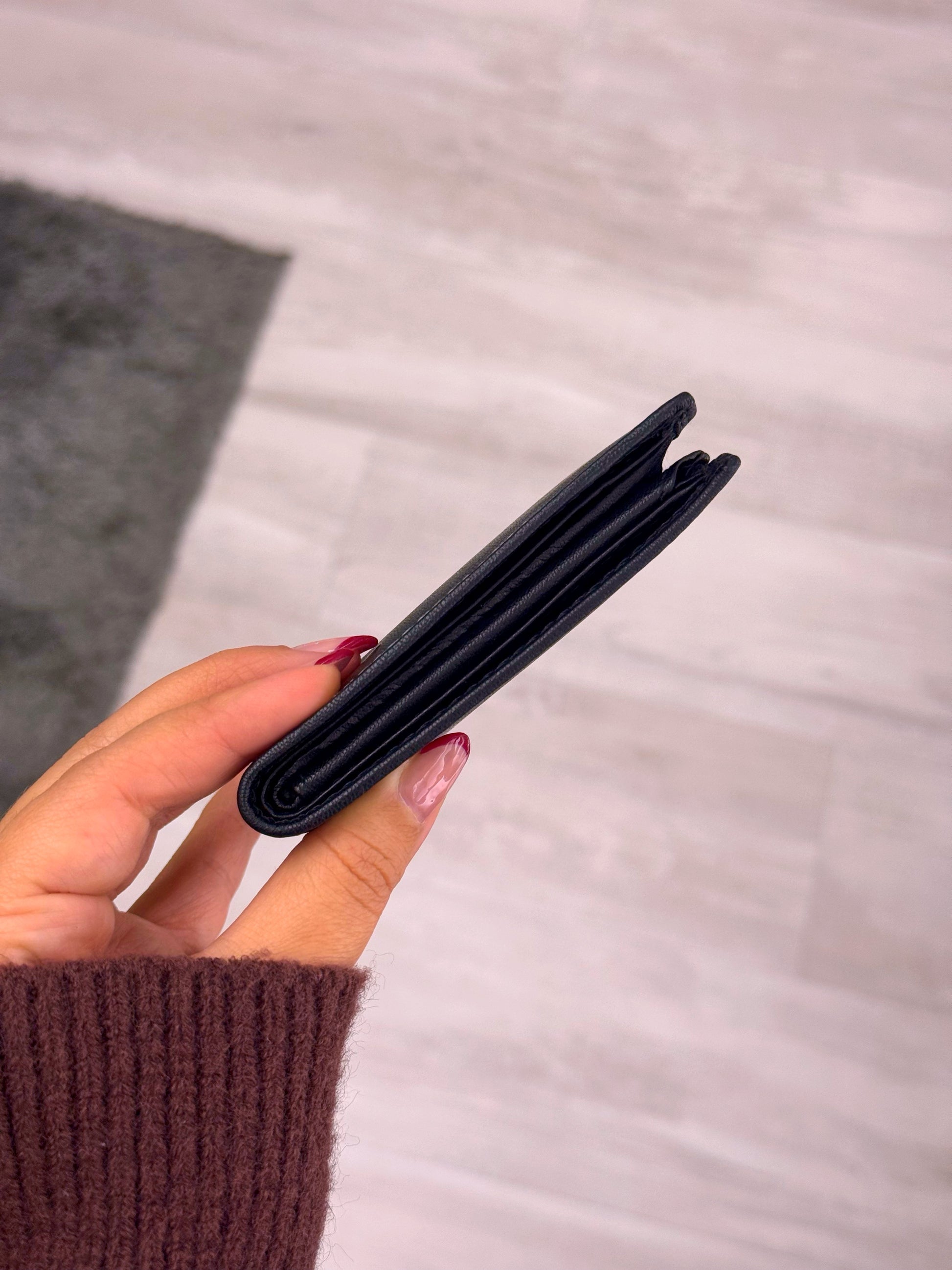 Carteira em pele preta com costura em contraste