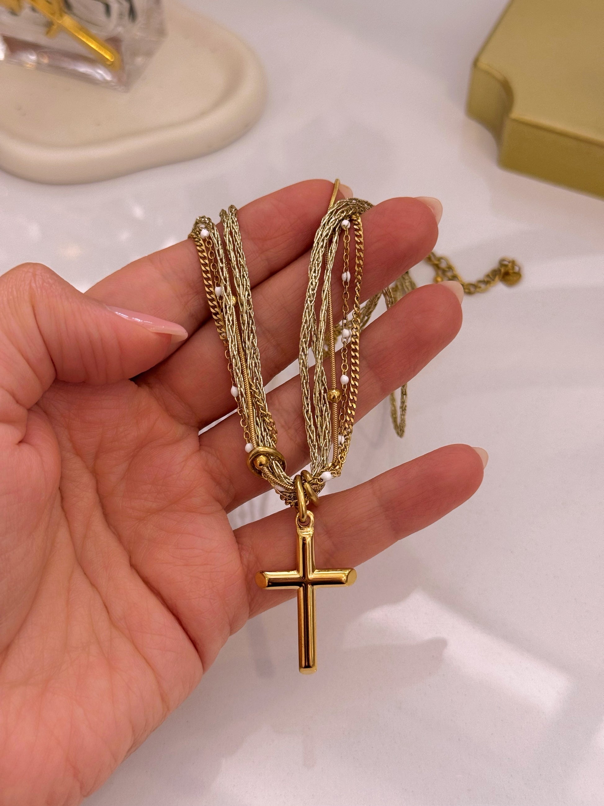 Colar multicamadas com mix de malhas e pendente cruz | Dourado
