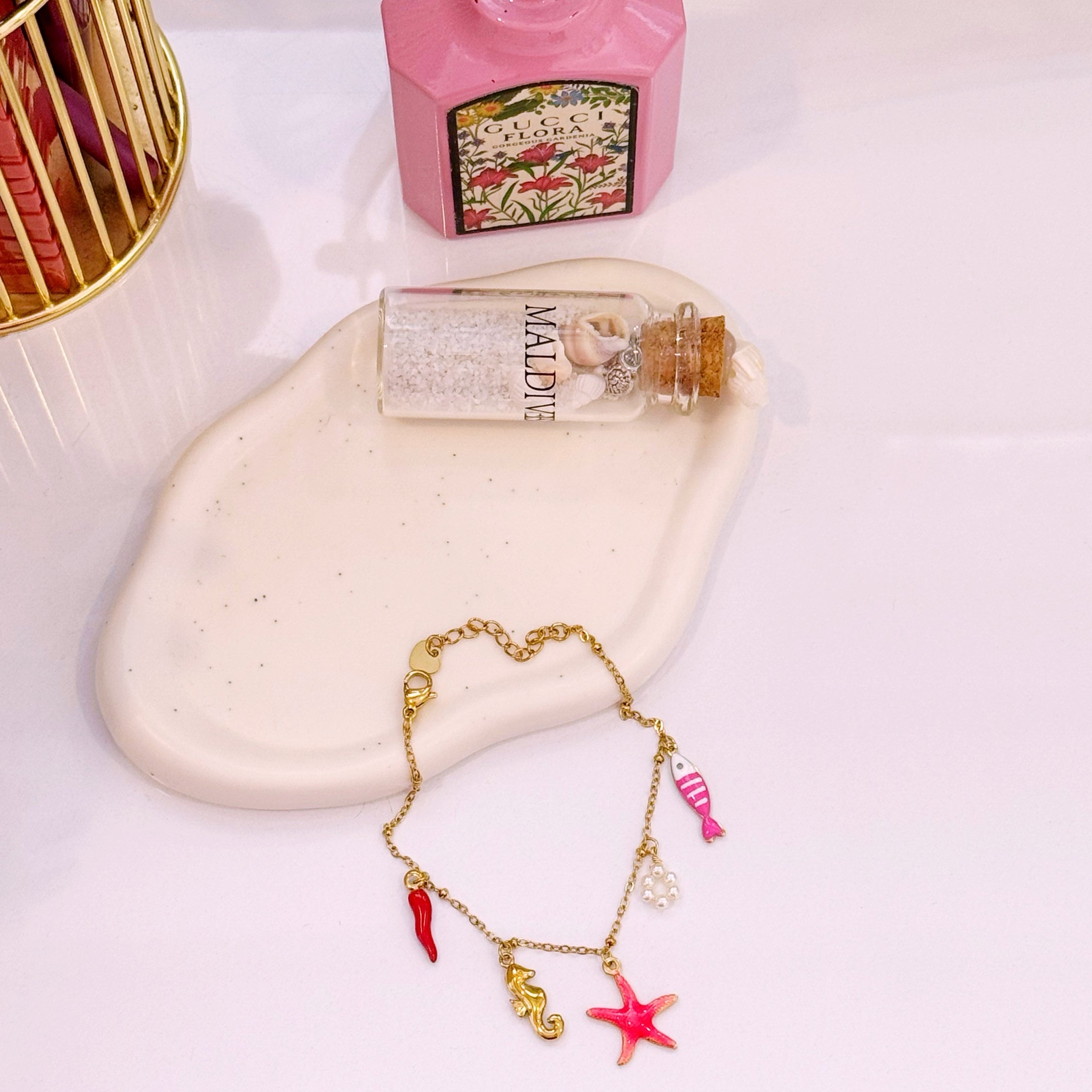 Pulseira com estrela do mar rosinha e vários pendentes | Dourado