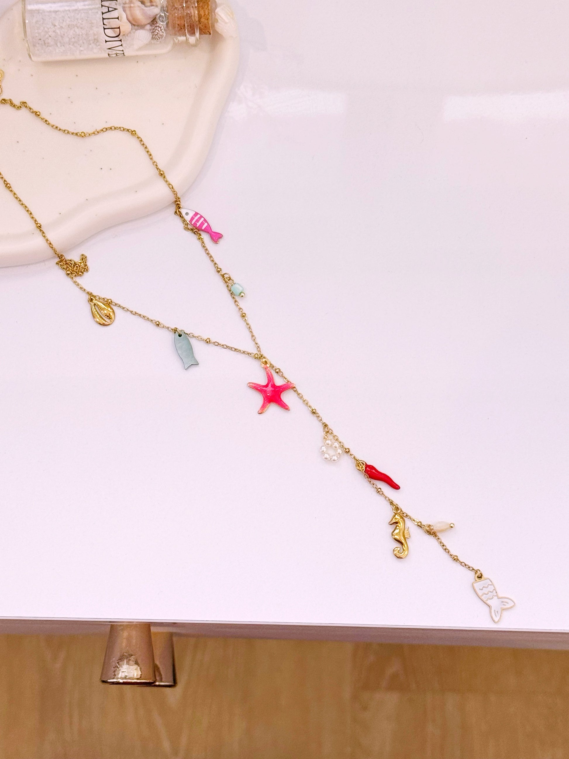 Colar com estrela do mar rosinha e vários pendentes | Dourado