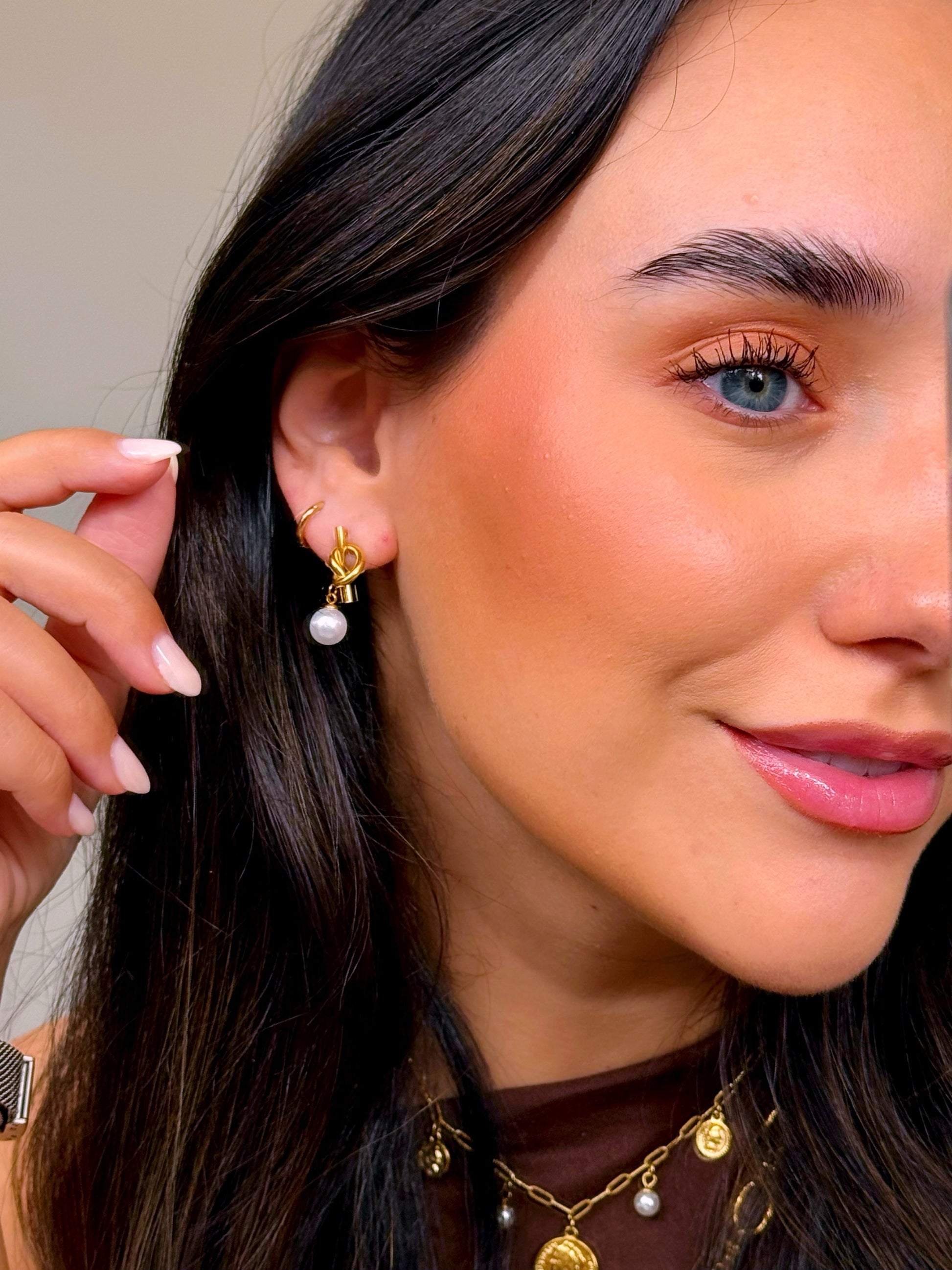 Brincos efeito nó com pérola em pendente | Dourado