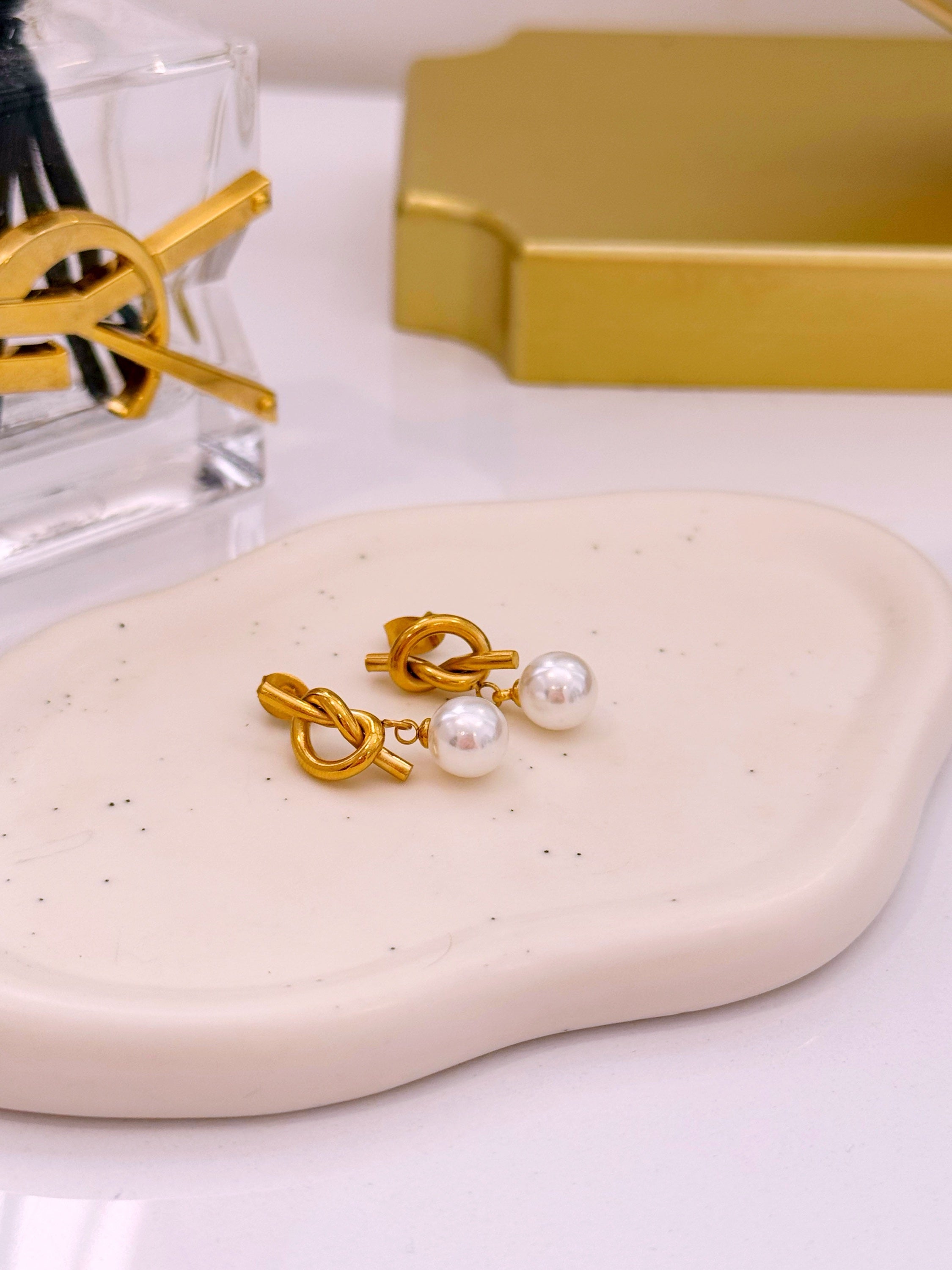 Brincos efeito nó com pérola em pendente | Dourado