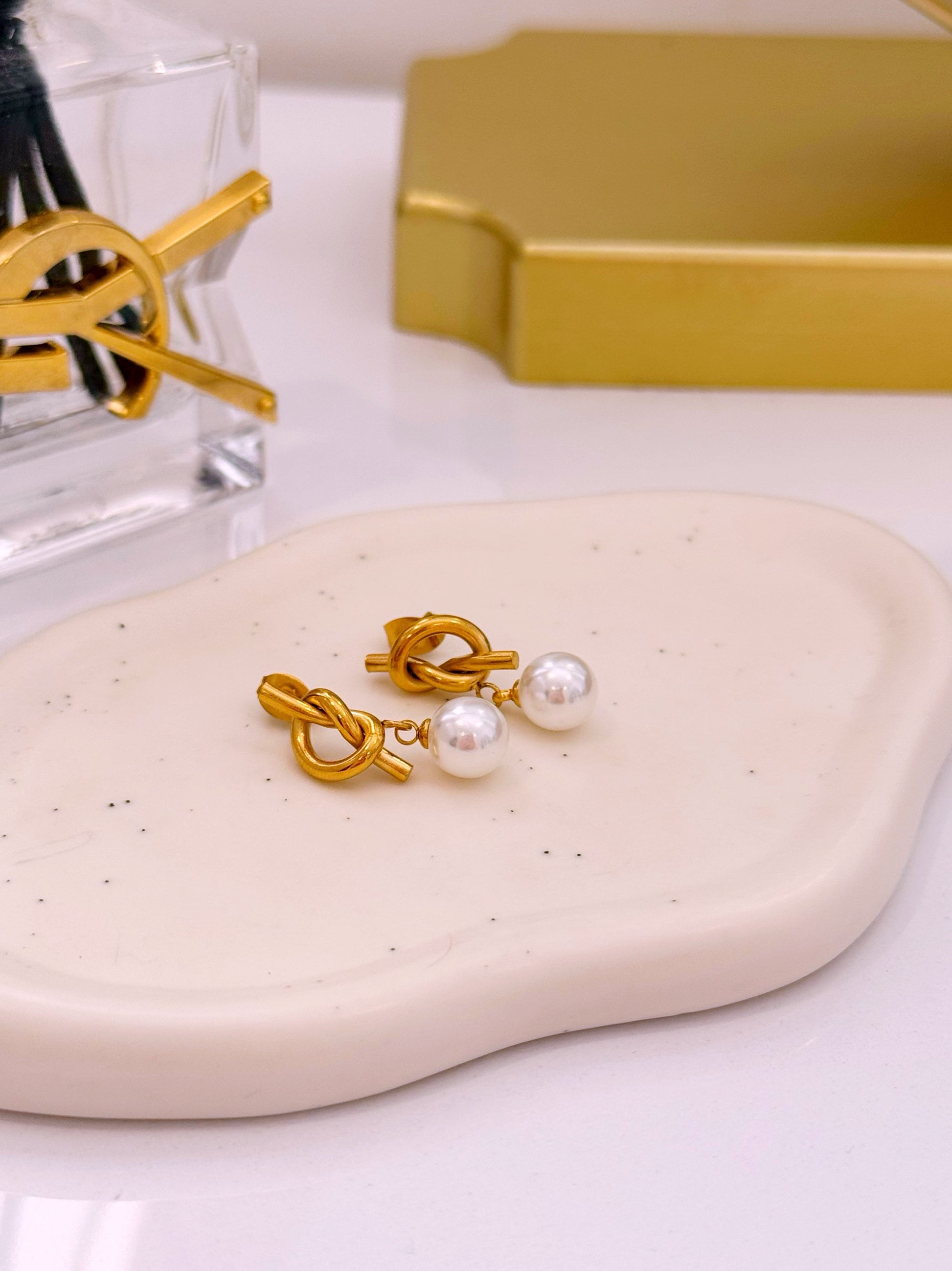 Brincos efeito nó com pérola em pendente | Dourado