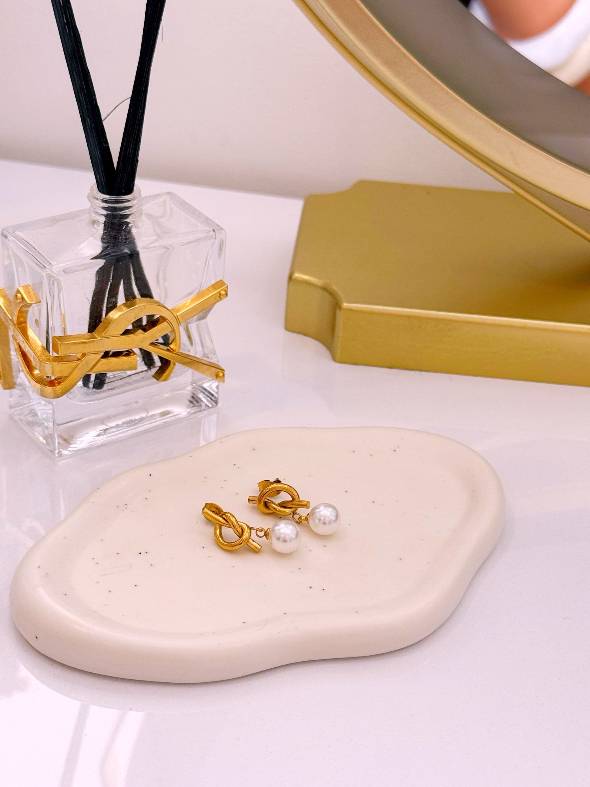 Brincos efeito nó com pérola em pendente | Dourado